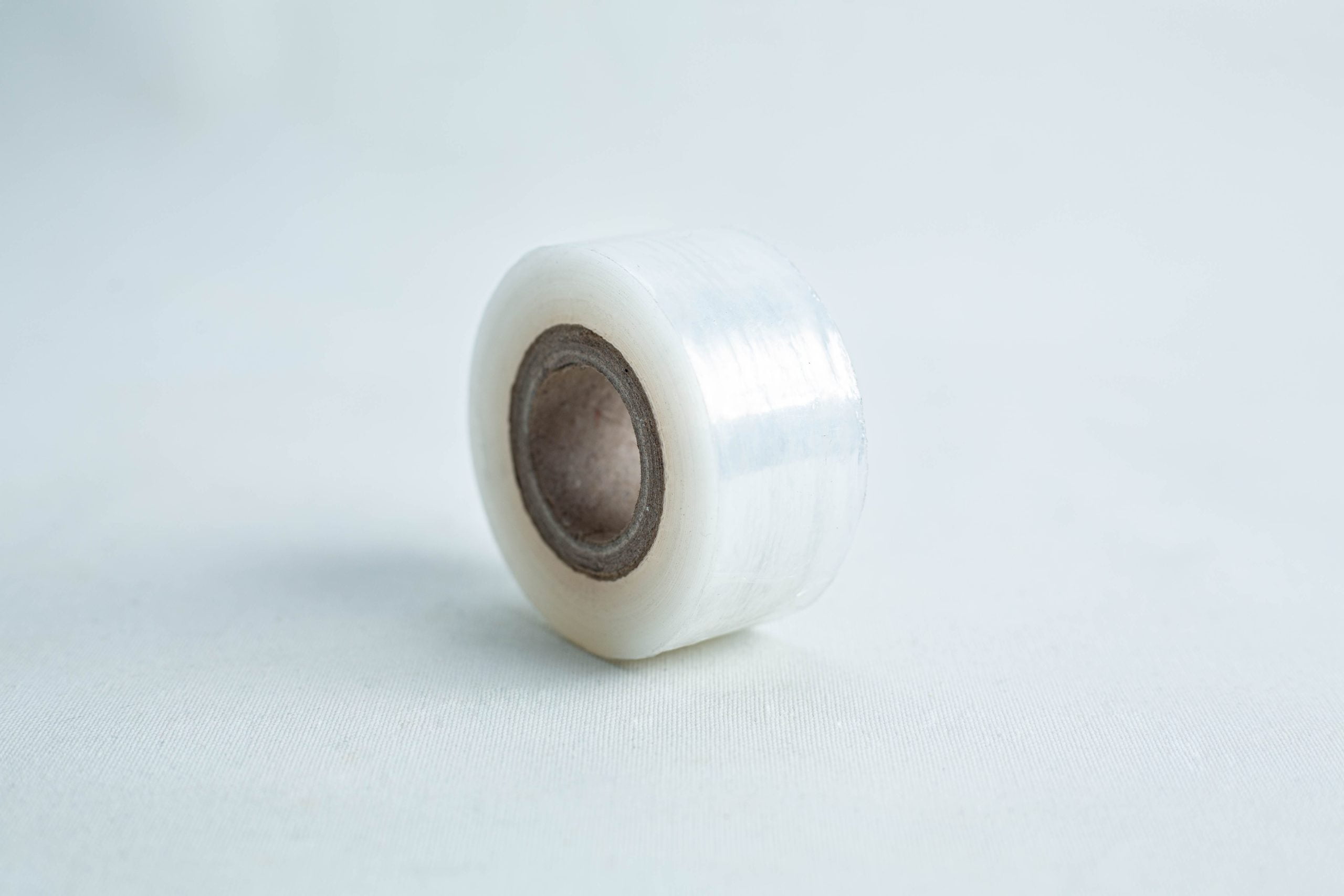 Grafting Tape to seal agar plates or for plant grafting 1 A small roll of Grafting Tape to seal agar plates or for plant grafting, with a brown cardboard core, rests on a light surface.
