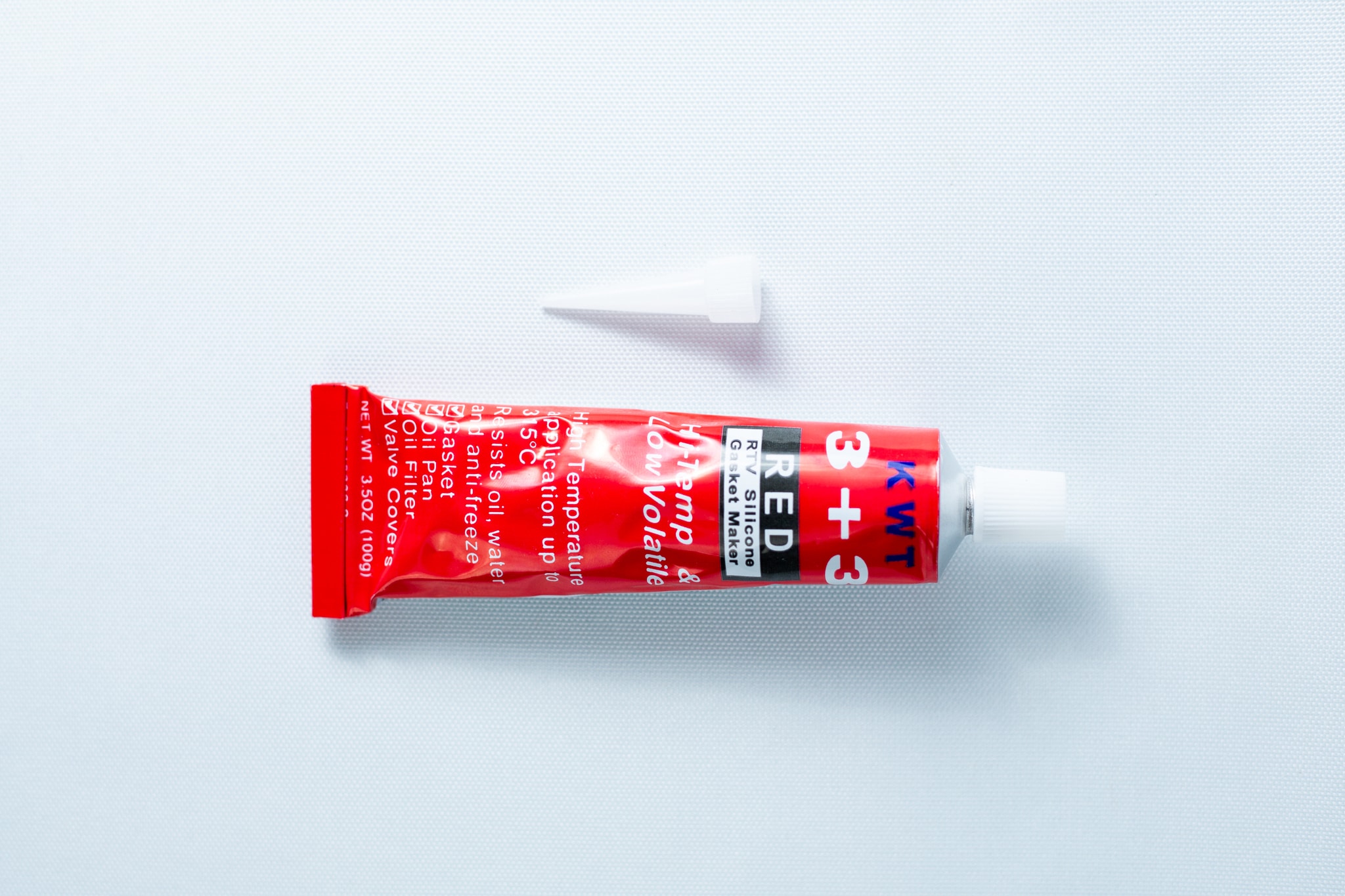 High Temperature RTV Silicon-Red 1 A red tube of High Temperature RTV Silicone-Red with a white cap placed above it on a white background.