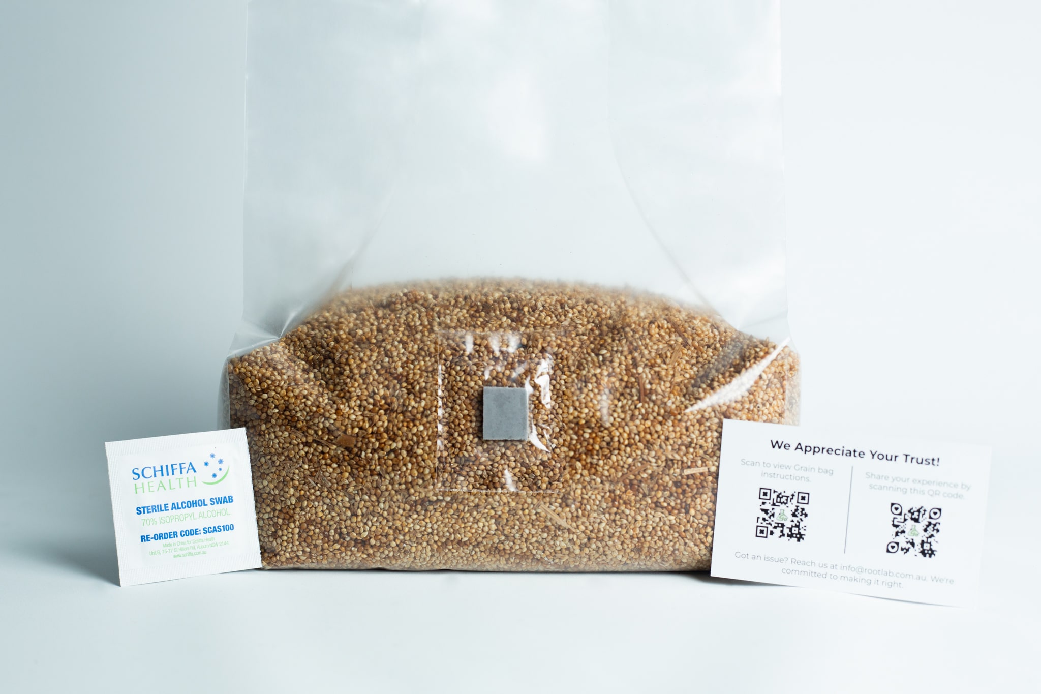 Millet pre sterilized mushroom grains w/inj port and digital instructions 5 Clear bag of seeds with two business cards placed on either side against a white background.