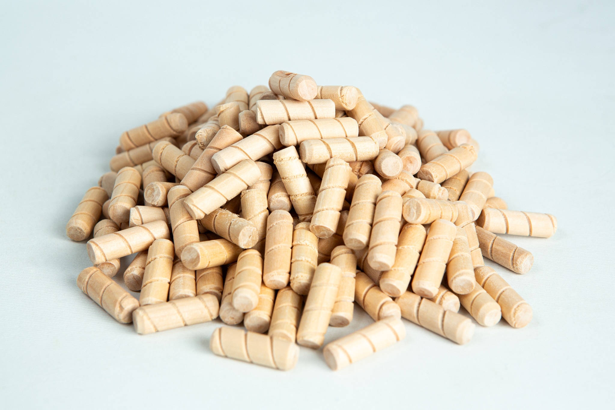 Uninoculated Birch Hardwood dowel plugs for mushroom logs 2 A pile of small, light wooden dowels on a white surface.