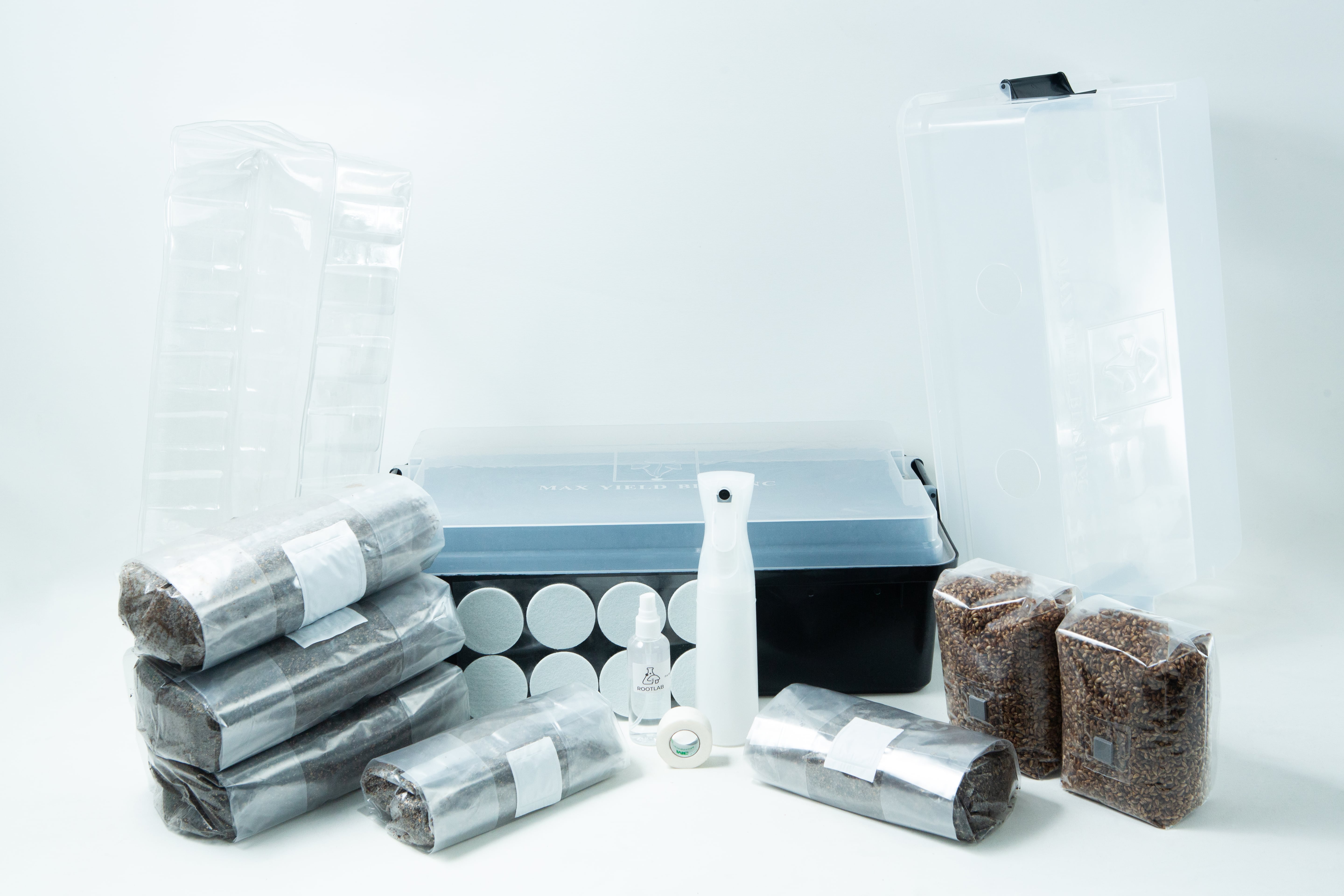 Monotub mushroom growing kit- Max Yield Bins 1 A mushroom growing kit with substrate bags, a clear tub, spray bottle, and accessories on a white background.