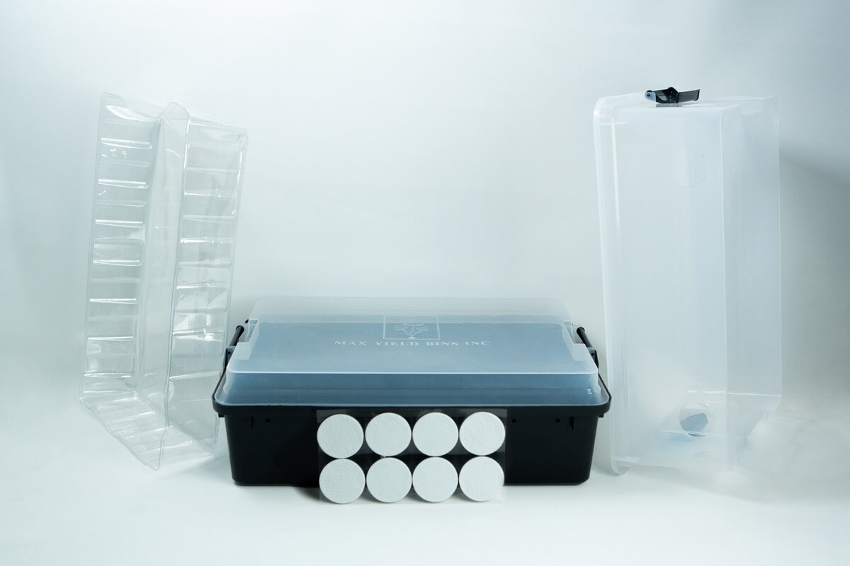 Monotub mushroom growing kit- Max Yield Bins 2 A plastic tub, two clear trays, eight round discs, and a tall clear container on a white background.