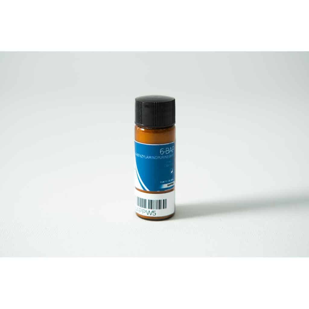 A small brown bottle labelled "Plant Cell Benzylaminopurine (6-BAP) Powder" with a blue label, black cap, and barcode sits on a white surface.