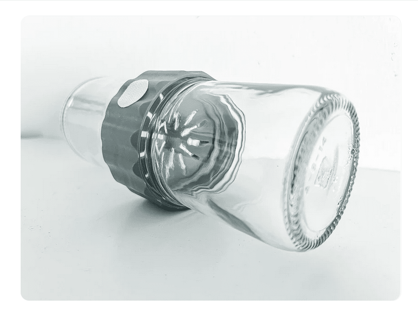 Plant Cell Biocoupler™ collar only (regular mouth) 10 A Plant Cell Biocoupler™ Glass Set (16oz, 12oz, 8oz) glass is placed upside down over a citrus juicer reamer on a white surface.