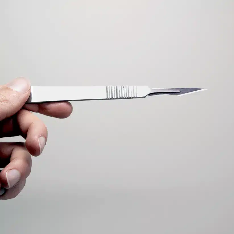 Plant Cell Tissue Culture Starter Kit 10 A hand holds a surgical scalpel against a light background, ready to start tissue culture using the Plant Cell Tissue Culture Starter Kit.