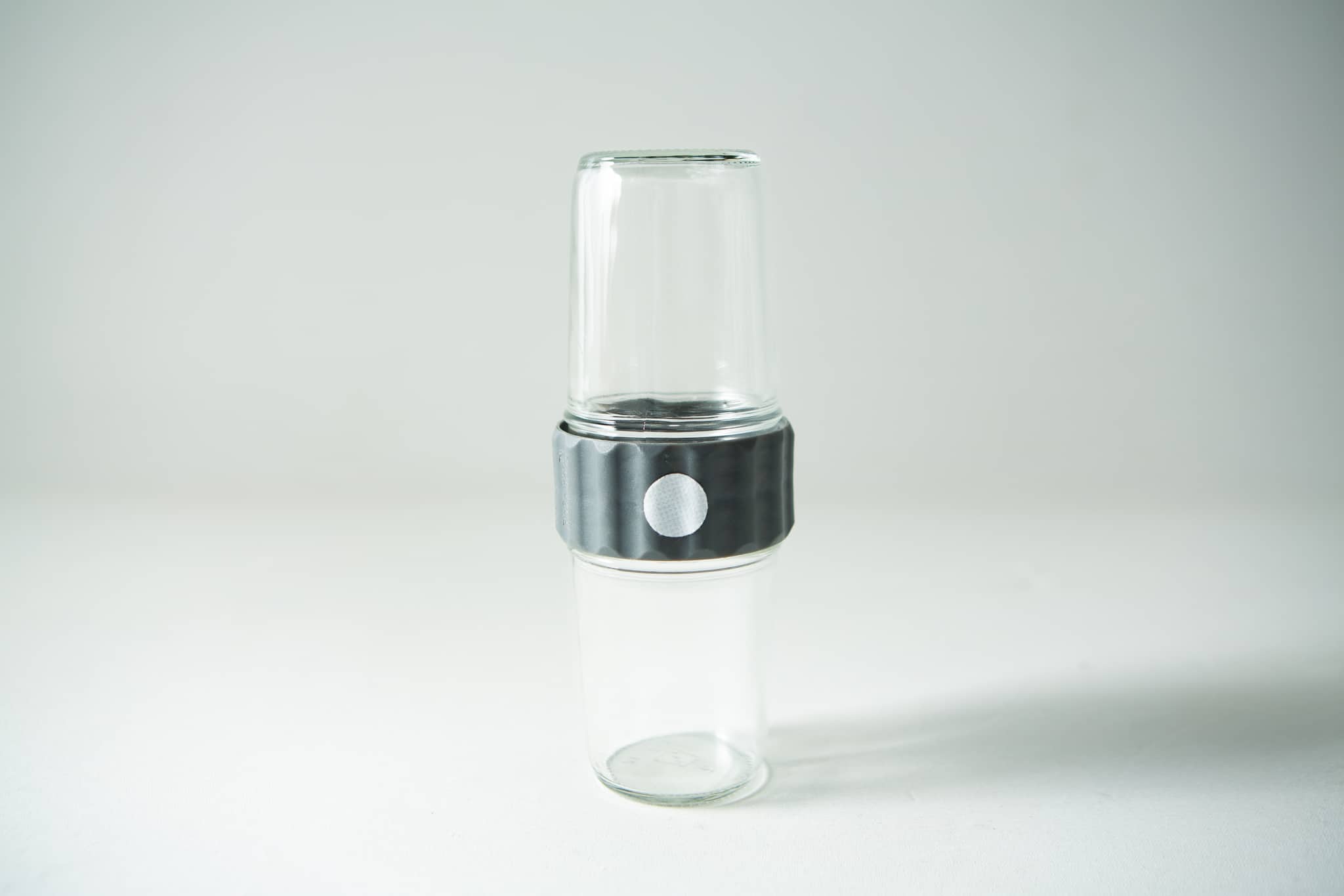 Plant Cell Biocoupler™ collar only (regular mouth) 4 The Plant Cell Biocoupler™ Glass Set (454ml, 340ml, 227ml) features two transparent glass tumblers stacked with a grey ribbed connector around their middles, shown against a white background.