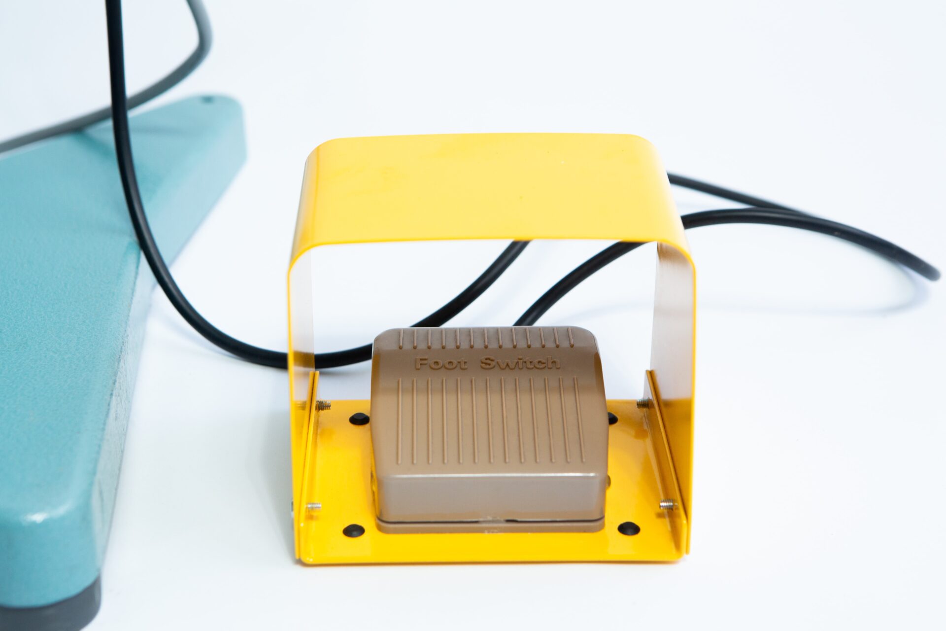 Vertical Foot Heat Sealer VHVD 450mm Double 10mm | Venus 3 The Vertical Foot Heat Sealer VHVD 450mm Double 10mm by Venus features a yellow-covered foot switch with cable, positioned on a white surface beside green equipment.