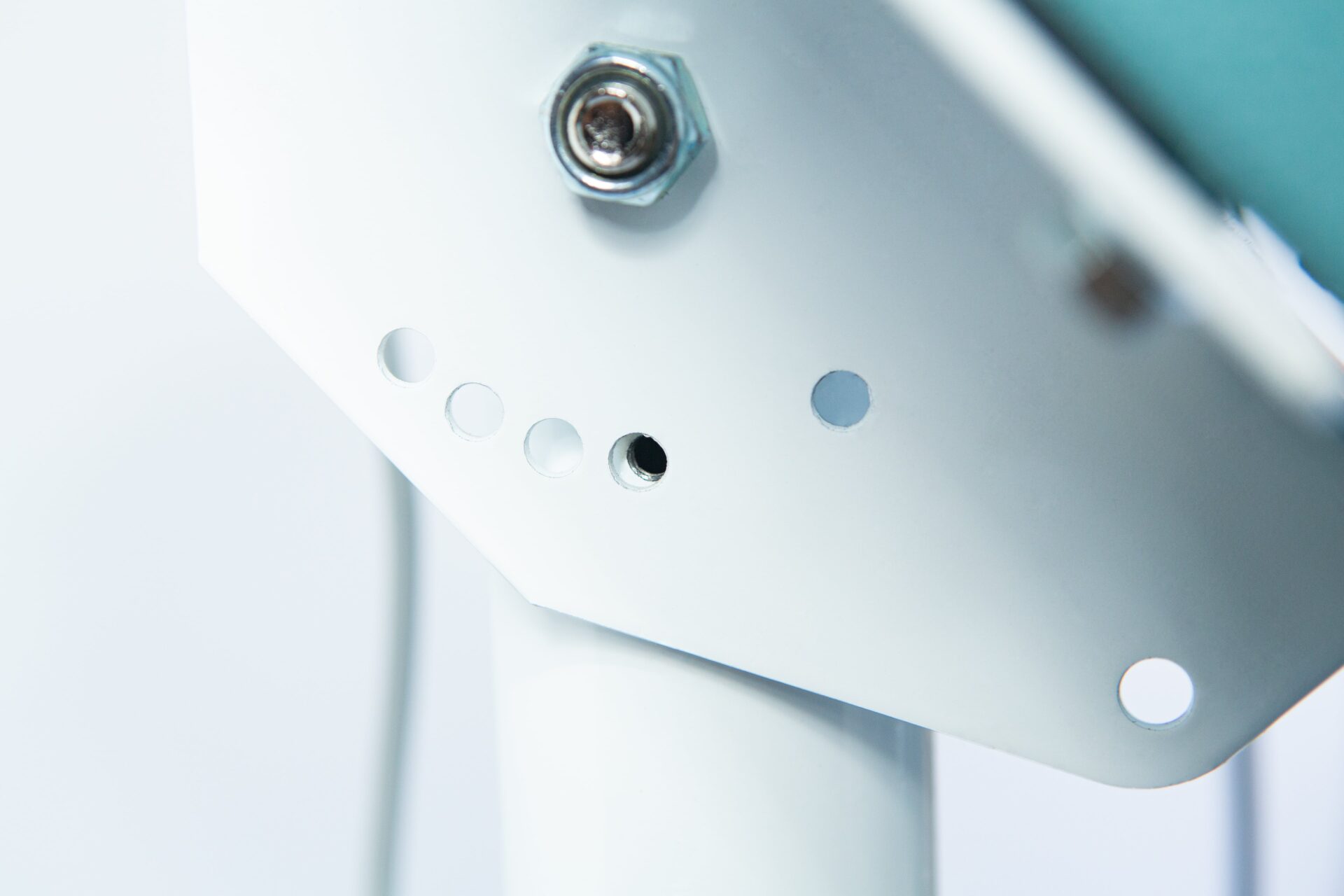 Vertical Foot Heat Sealer VHVD 450mm Double 10mm | Venus 6 Close-up of the Vertical Foot Heat Sealer VHVD 450mm Double 10mm by Venus, showing a white metal bracket with several small circular holes and a bolt.