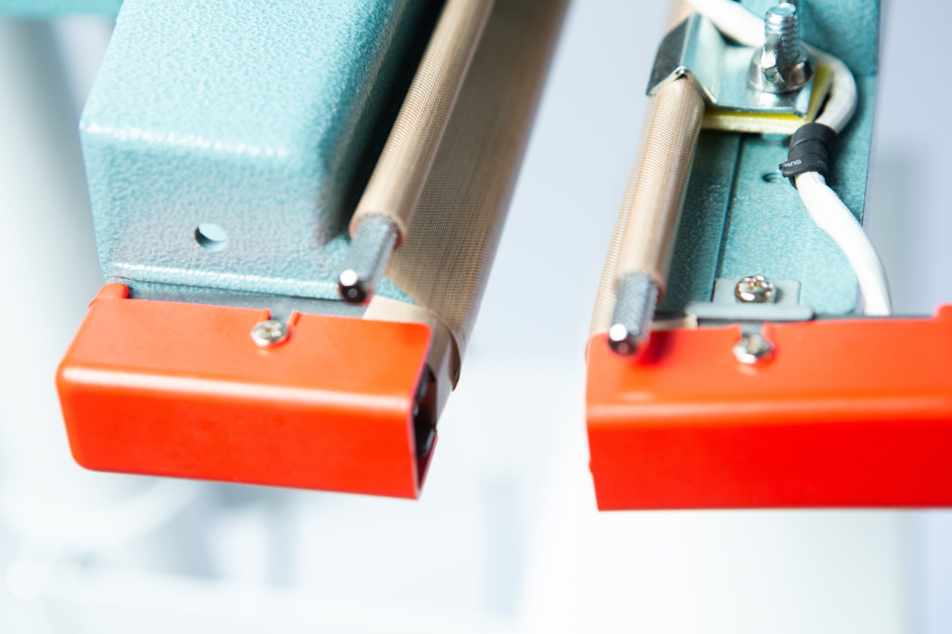 Vertical Foot Heat Sealer VHVD 450mm Double 10mm | Venus 4 Close-up of the Vertical Foot Heat Sealer VHVD 450mm Double 10mm by Venus, featuring orange end caps and attached wires.