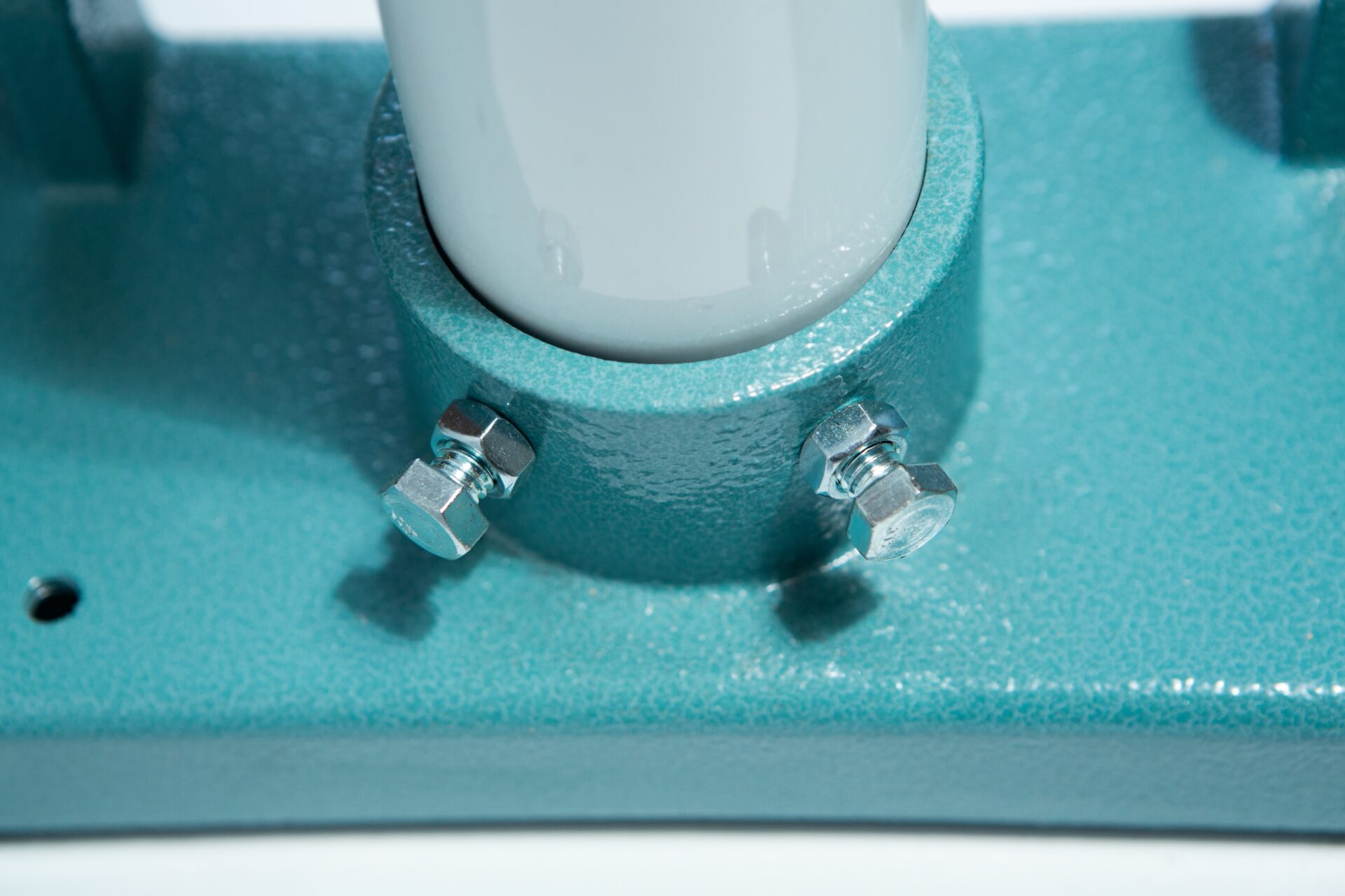 Vertical Foot Heat Sealer VHVD 450mm Double 10mm | Venus 7 Close-up of two bolts securing the Vertical Foot Heat Sealer VHVD 450mm Double 10mm by Venus to a white cylindrical pole in a textured teal metal base.