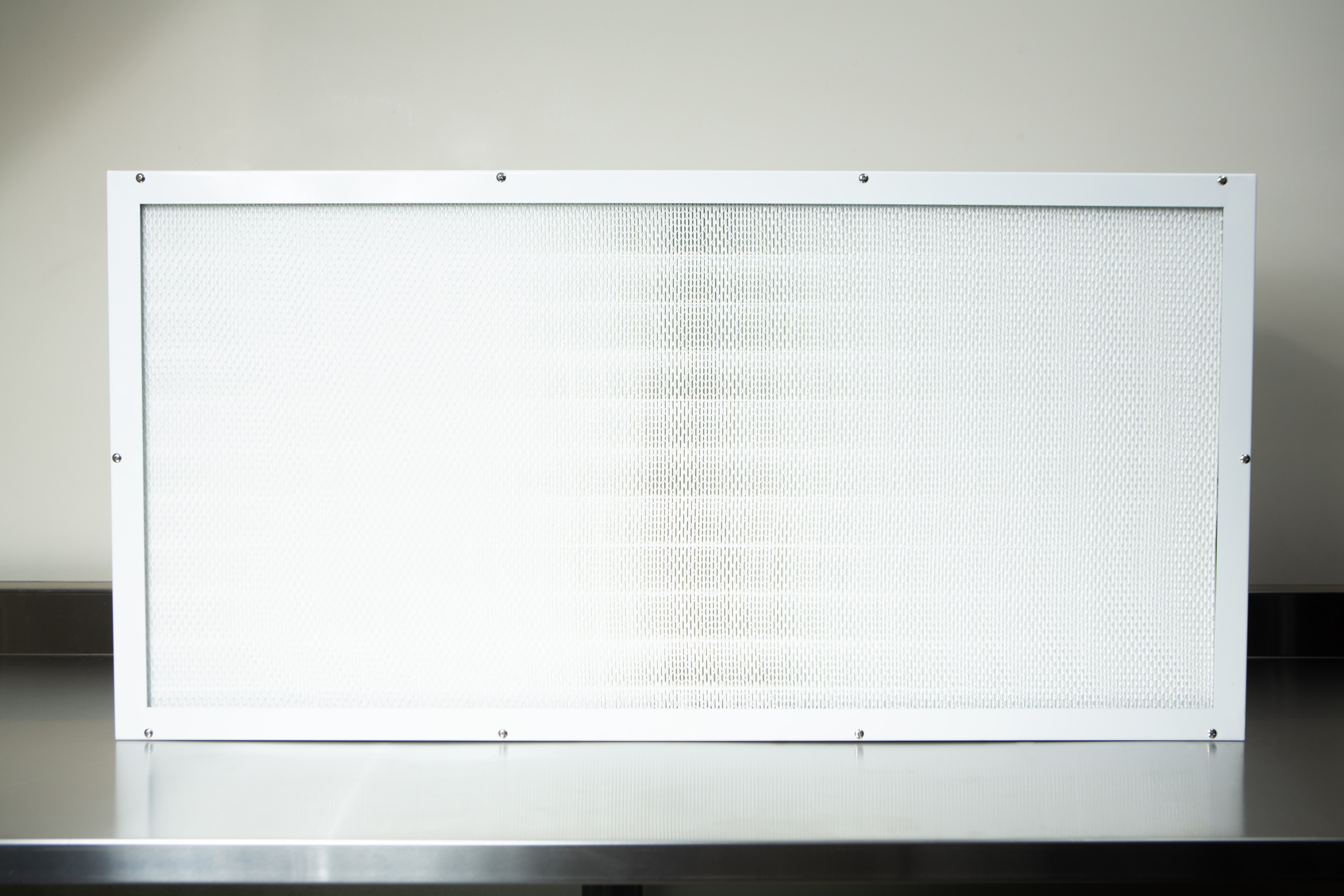 Laminar Flow Hood H14 w/prefilter 120x60x35cm 1 The Laminar Flow Hood H14 with pre-filter (120x60x35cm) features a rectangular white-framed air filter, shown on a metallic surface against a light background.