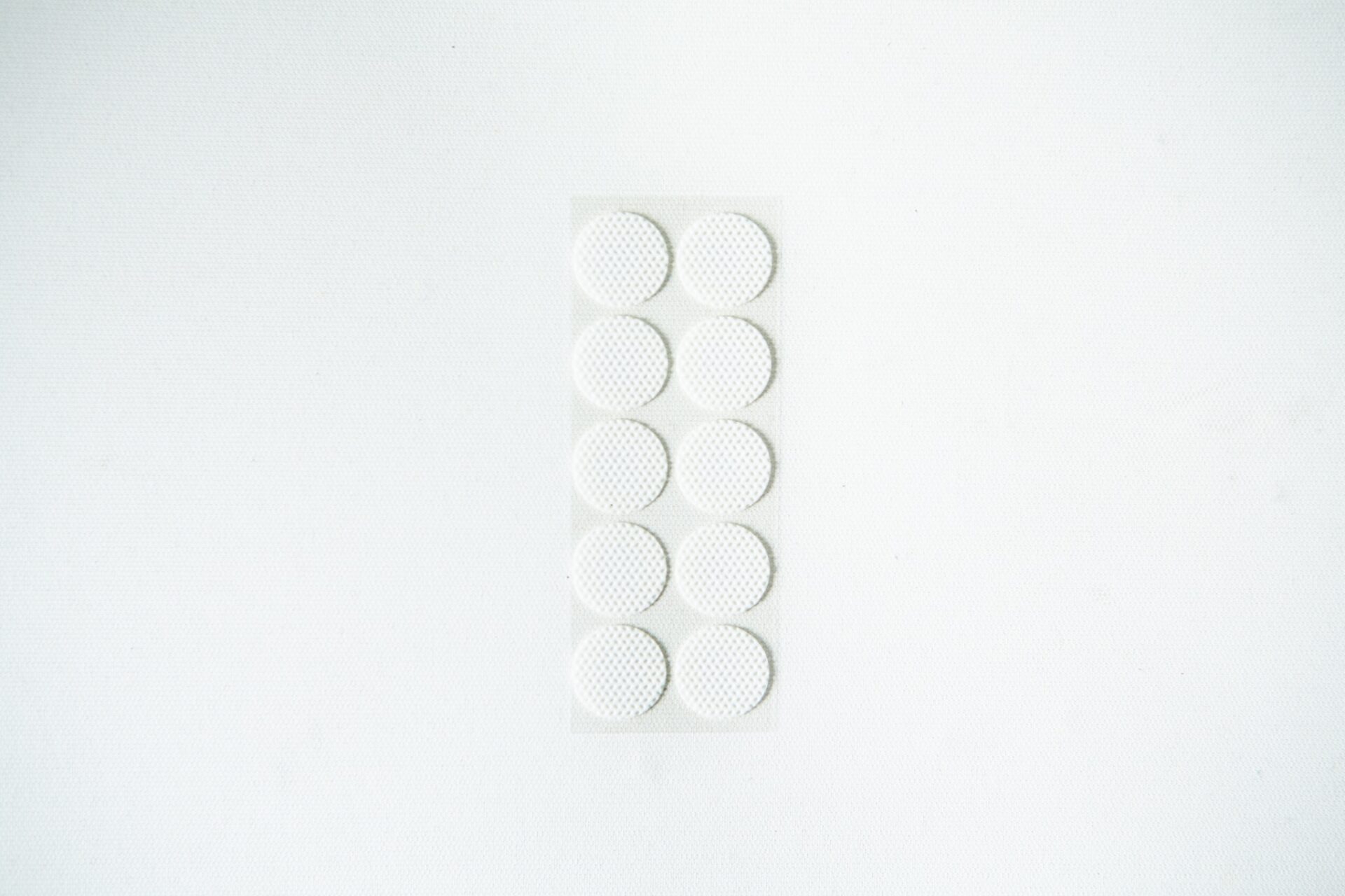 Self-healing injection port & Air Vent Filter-3M 9 A blister pack containing ten round, white tablets on a plain white background.