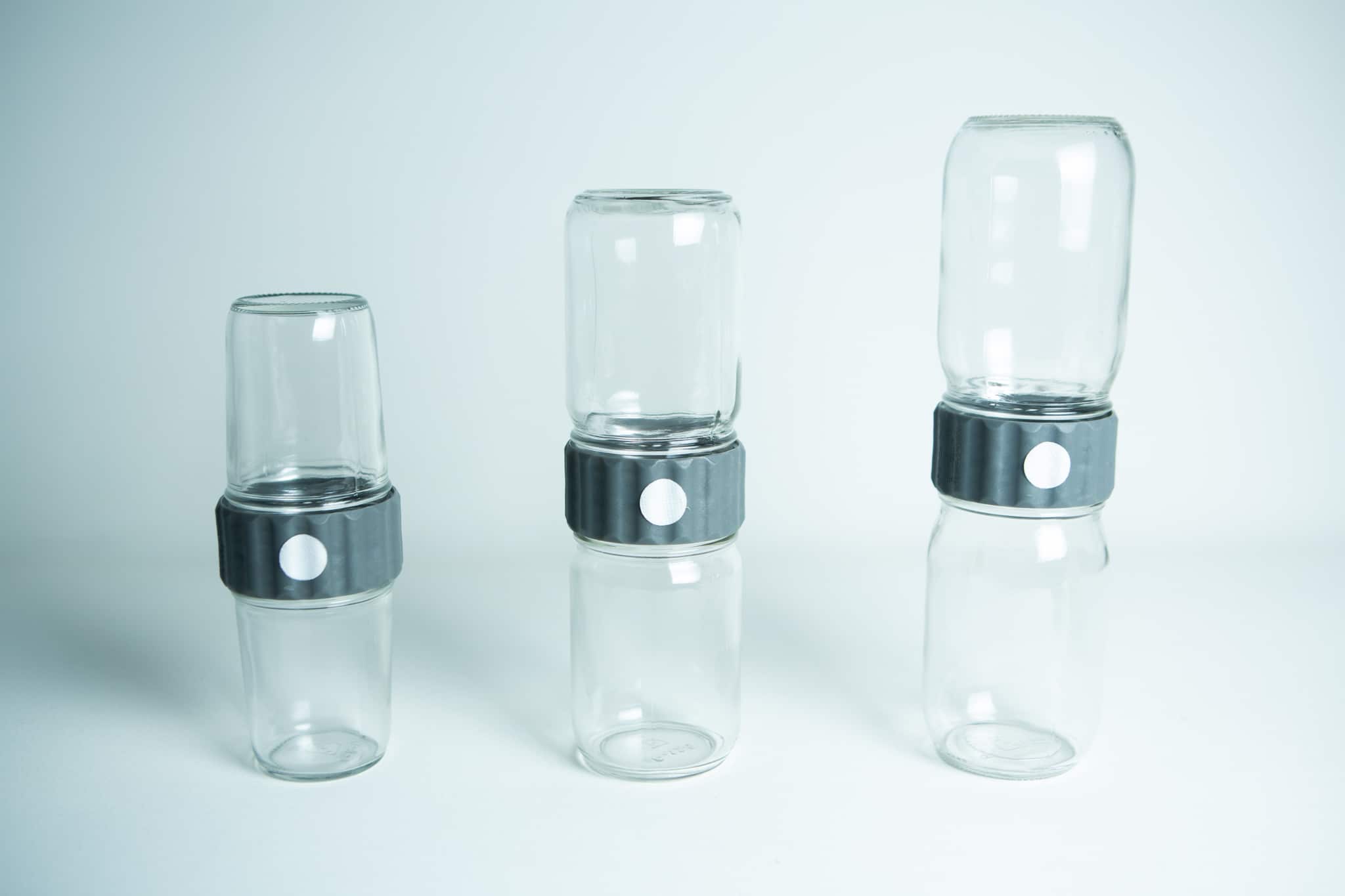 Plant Cell Biocoupler™ Glass Set 16oz, 12oz, 8oz 1 Three stacked pairs of Plant Cell Biocoupler™ Glass jars (454ml, 340ml, 227ml) joined by black lids with white buttons, arranged from left to right.