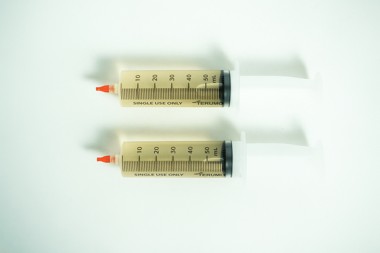 Mushroom Liquid Culture | Lion’s Mane Pride | Hericium erinaceus | Commercial 3 Two large syringes of Liquid culture to Liquid culture expansion Kit, filled with yellowish liquid, are placed side by side on a white surface.