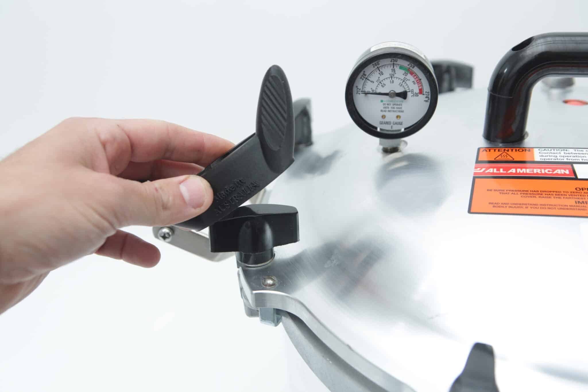 Wingnut Wrench for All American Steriliser | Rootlab Original | 3D Printed 3 A hand turns the locking mechanism on the lid of an All American Tool pressure cooker with a pressure gauge.