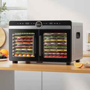The Devanti 16 Trays Food Dehydrator Dual-Zone Stainless Steel, filled with trays of sliced fruit and vegetables, sits on a kitchen worktop.