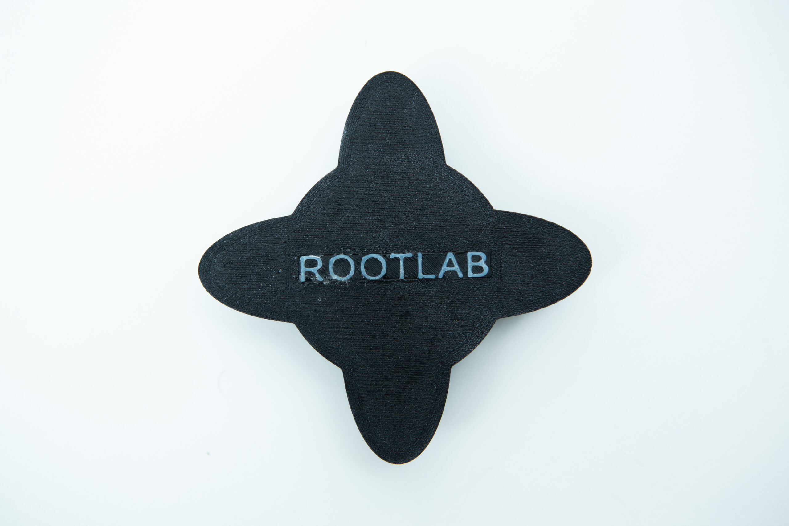 Reagent Bottle Cap Wrench | Rootlab Original | 3D Printed 4 Black, four-pointed petal-shaped object with ROOTLAB text in white at its centre, on a white background.