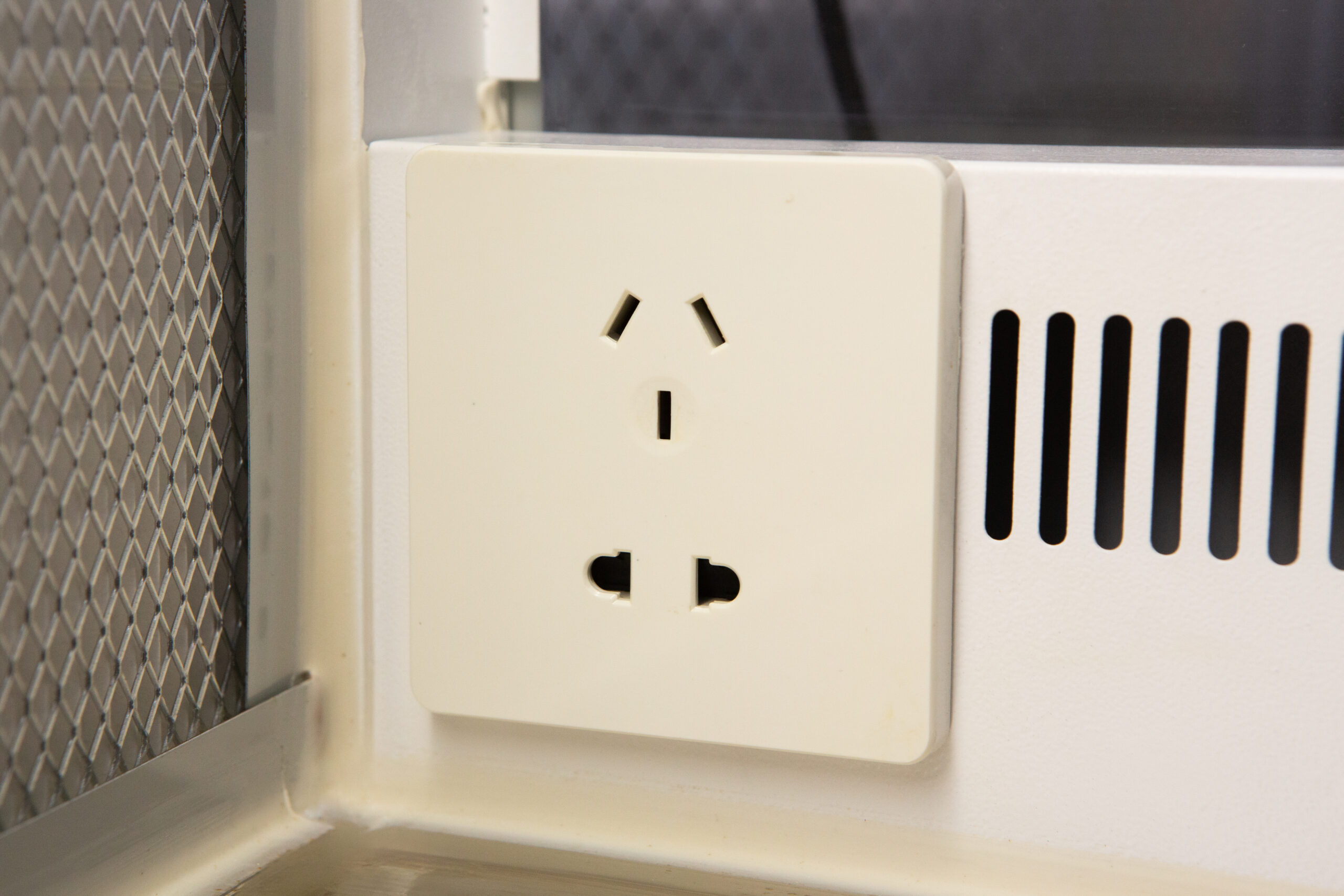 Horizontal Laminar Flowhood Cabinet | Clean bench 8 A close-up of a white electrical power socket on a wall, with three plug slots visible.