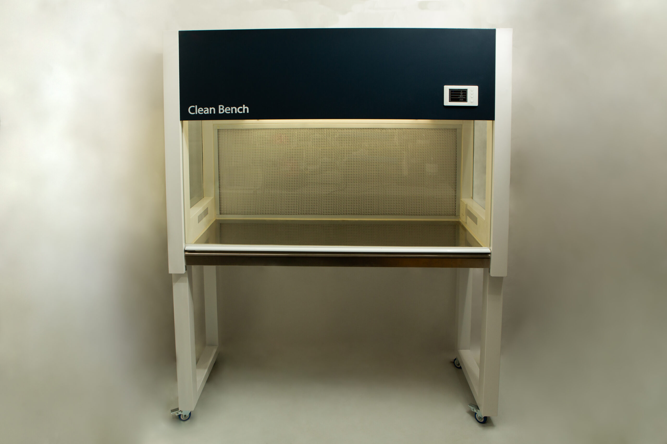 Horizontal Laminar Flowhood Cabinet | Clean bench 1 A laboratory clean bench with a glass work surface and overhead lighting, on four castors.