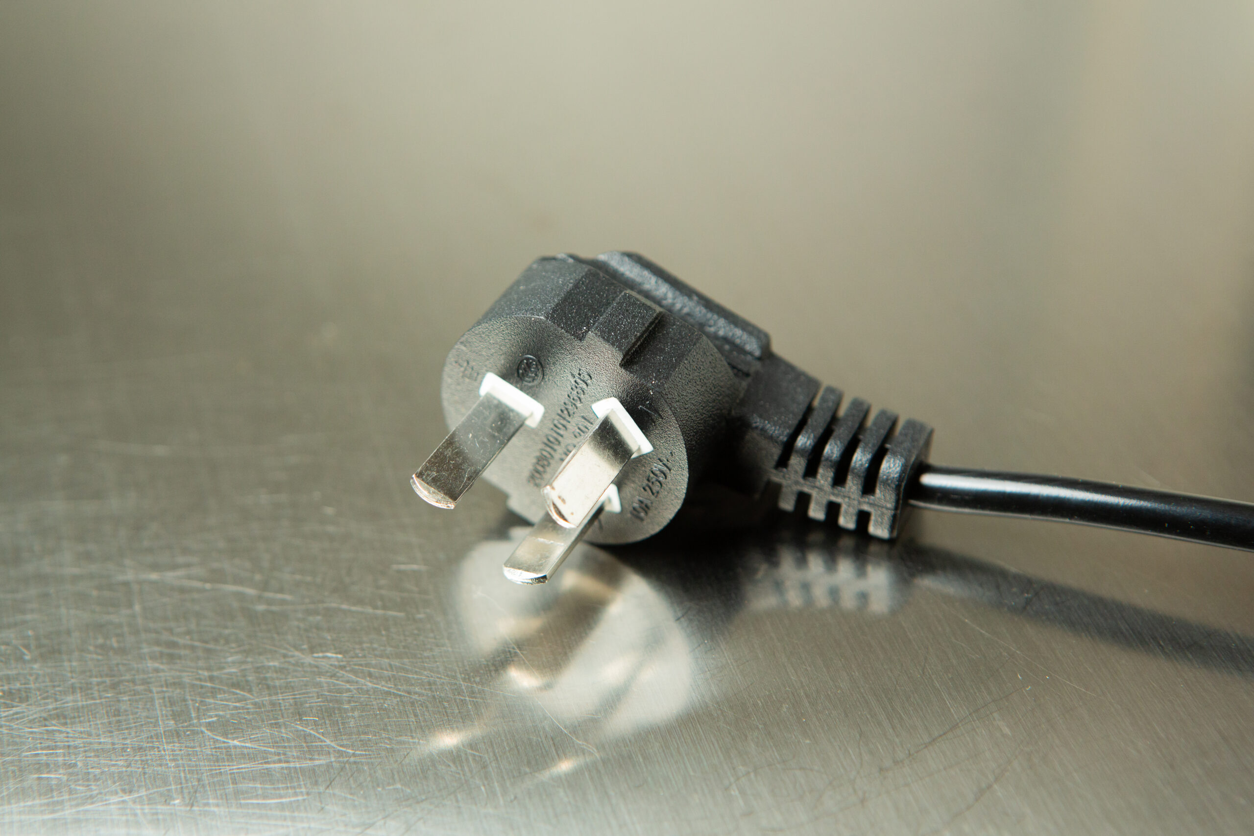 Horizontal Laminar Flowhood Cabinet | Clean bench 3 Close-up of a black three-pin electrical plug on a metallic surface.