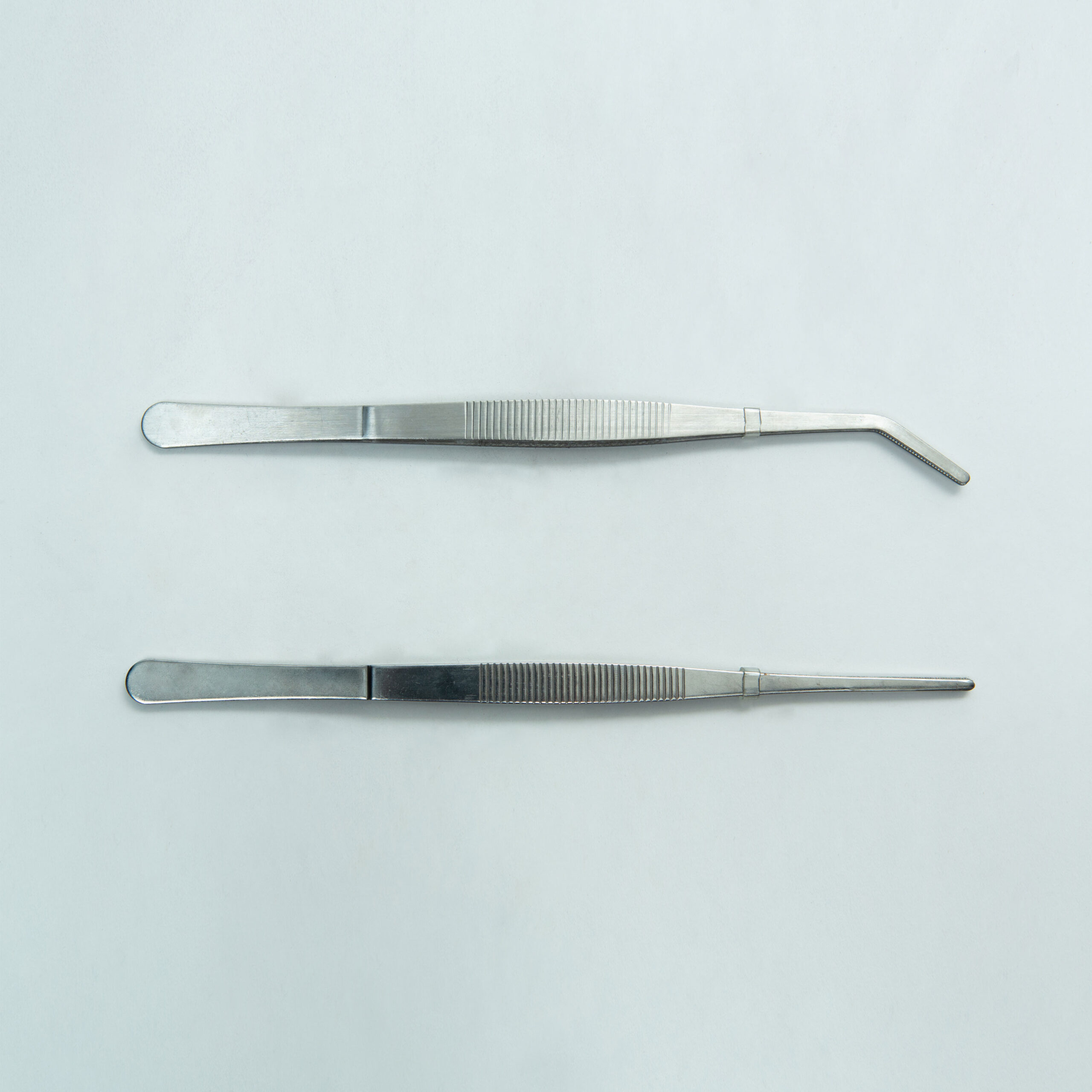 Stainless Steel Plant tissue culture Lab Forceps | Curved & Straight Tips | 25cm 1 Two stainless steel Plant Tissue Culture Lab Forceps, one with a straight tip and one with a curved tip (15 cm each), are shown on a plain light background. These forceps are ideal for precise handling in various laboratory applications.