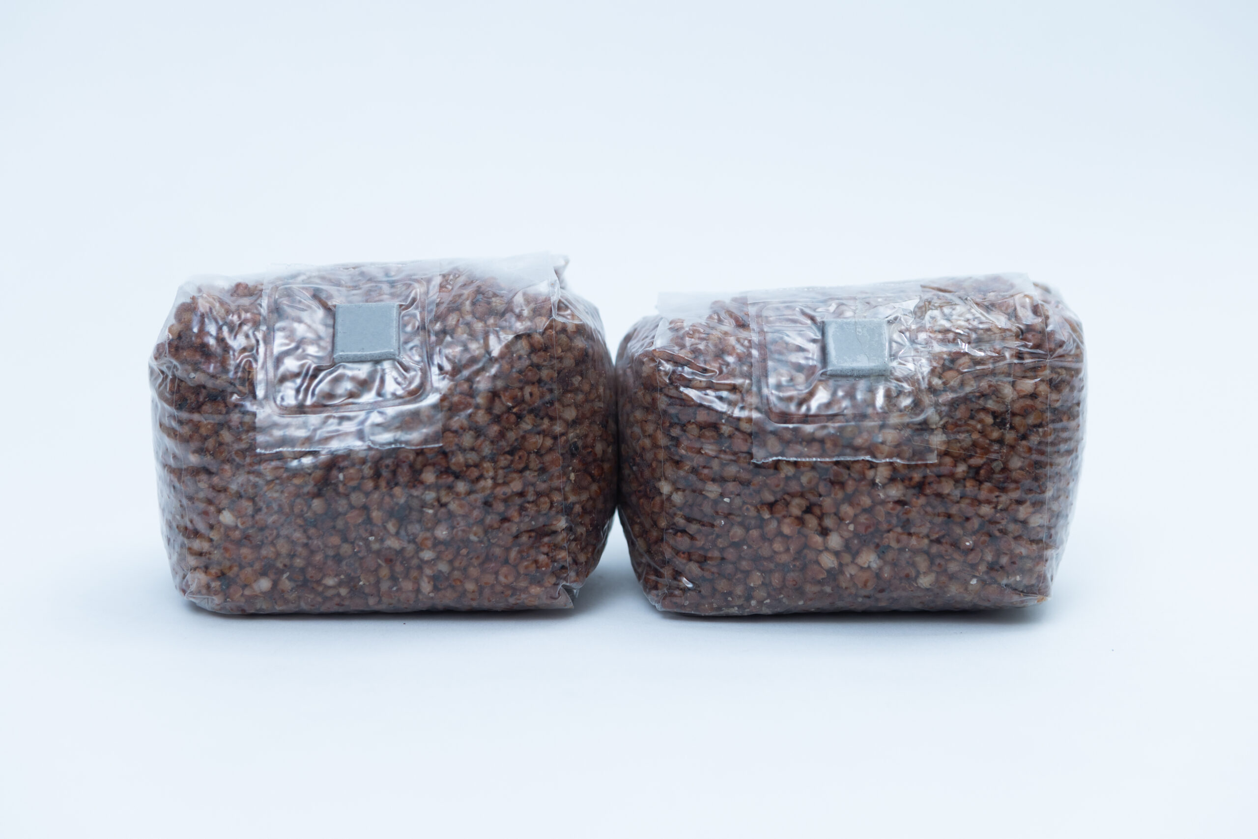 Mushroom Grain spawn Bag Pre Sterilised: Choose Rye, Millet or Sorghum (Milo) w/inj port and air filter 500gms 1 Two sealed plastic bags filled with brown grains, placed side by side on a plain white background.