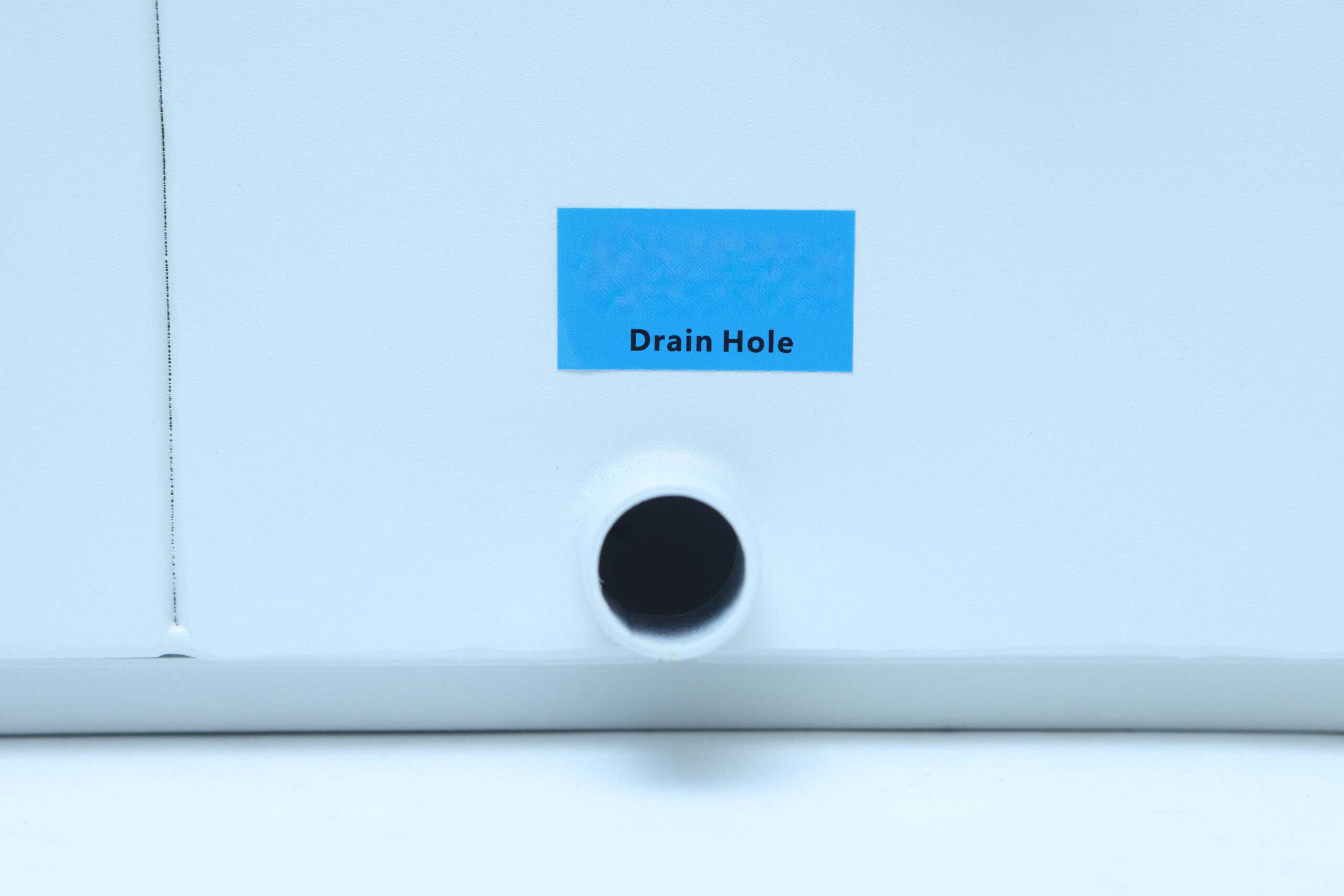 Industrial Heavy duty Ultrasonic Fogger 15L/H, Humidifier (AU 220V) 4 A blue label reading Drain Hole is above a circular drain hole on a white surface.